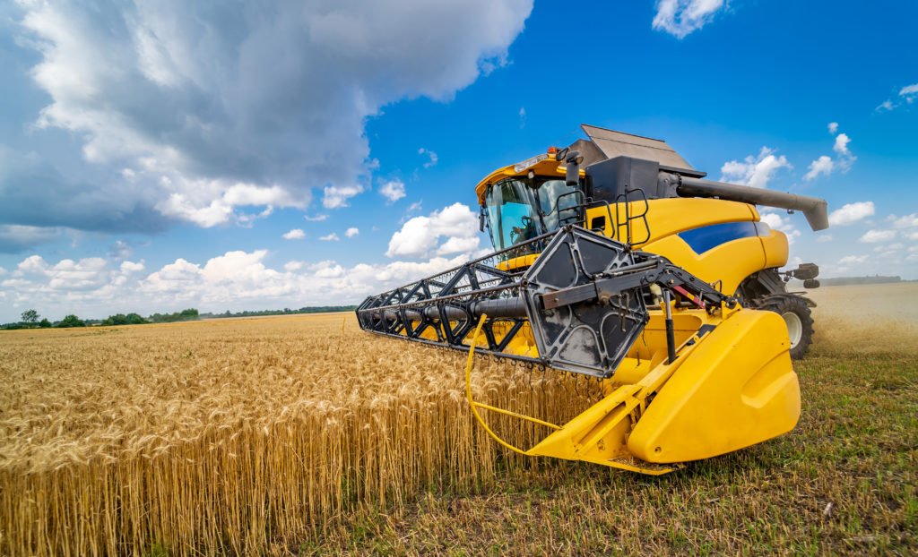 Colheitadeira operando no campo com segurança graças ao seguro de máquinas agrícolas.
