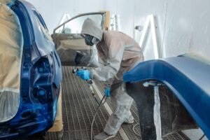 Carro sendo pintado em oficina automotiva