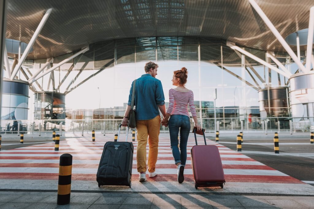 Casal com malas no aeroporto prontos para embarcar para Europa com seguro viagem