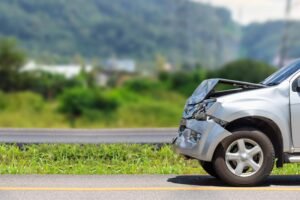 Carro acidentado na estrada representando situação não coberta pelo seguro