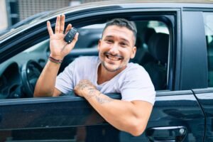 Pessoa feliz ao receber carro novo adquirido por consórcio