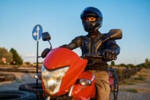 Motociclista equipado com capacete em uma estrada, representando a importância do seguro moto